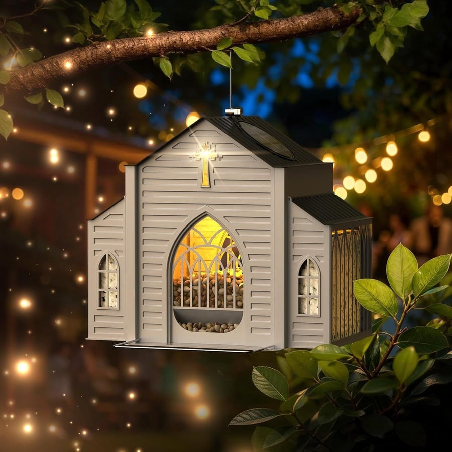 Church-shaped solar bird feeder hanging outdoors in a garden